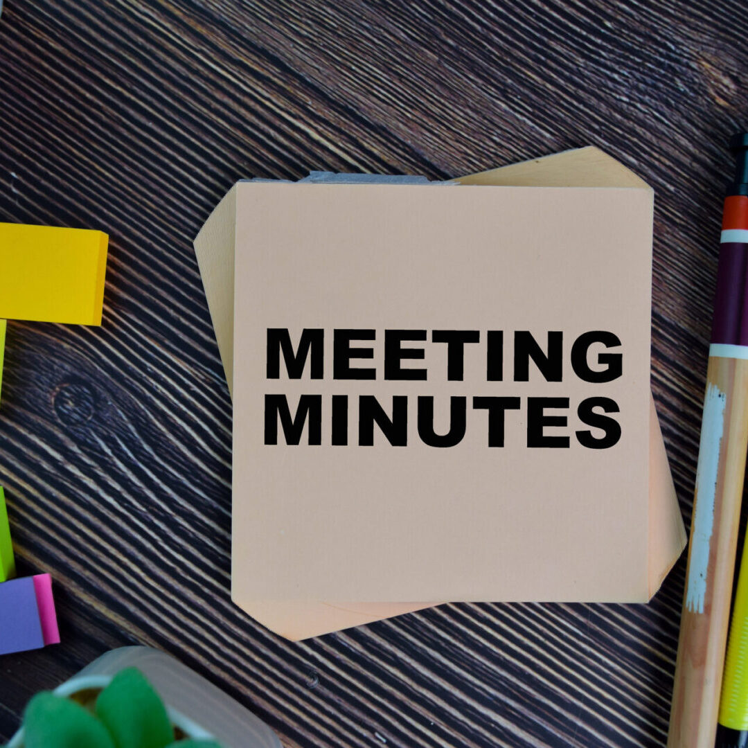 Meeting Minutes write on sticky notes isolated on Wooden Table.